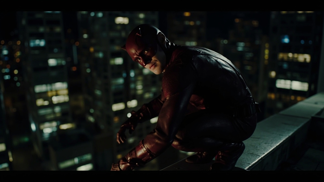 Charlie Cox as Daredevil in his red suit crouching on a Hell's Kitchen rooftop at night