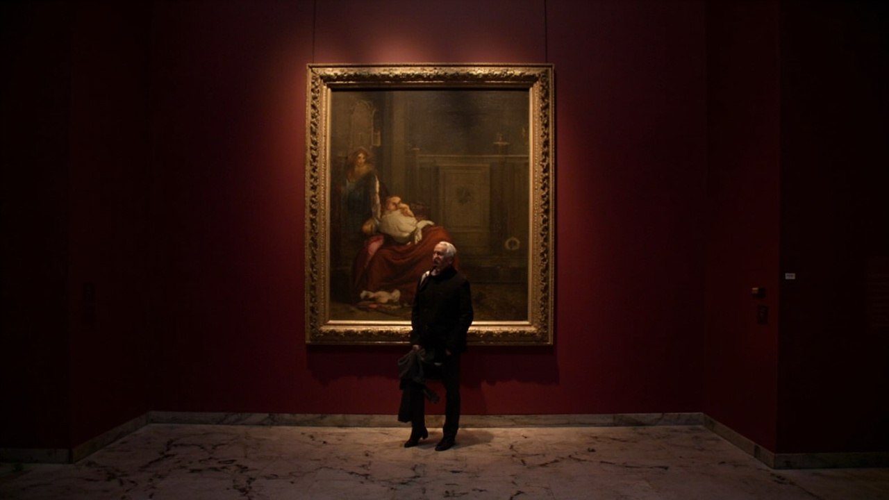 A Renaissance painting in an ornate gold frame on a deep burgundy gallery wall at the Metropolitan Museum of Art with soft overhead lighting