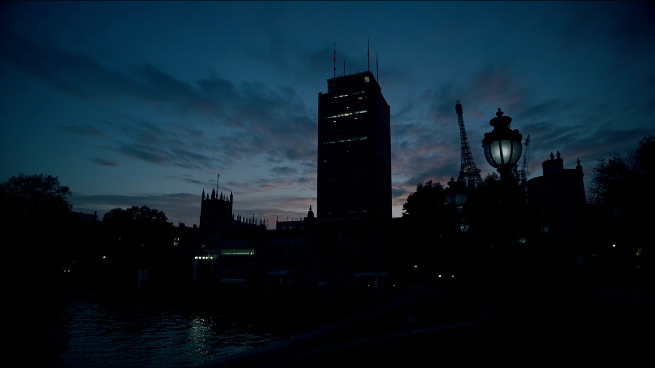 Silhouette of the MI6 headquarters at Vauxhall Cross in London at twilight with the Thames in the foreground