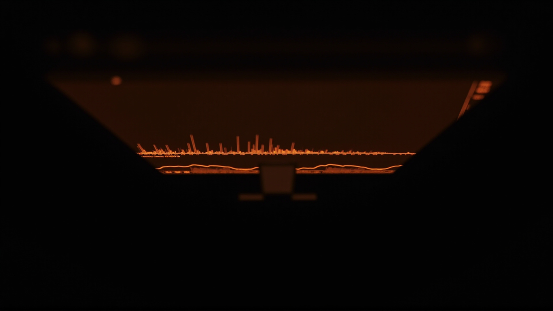 A cryptocurrency trading screen showing a flat price line, amber monitor glow, dark room