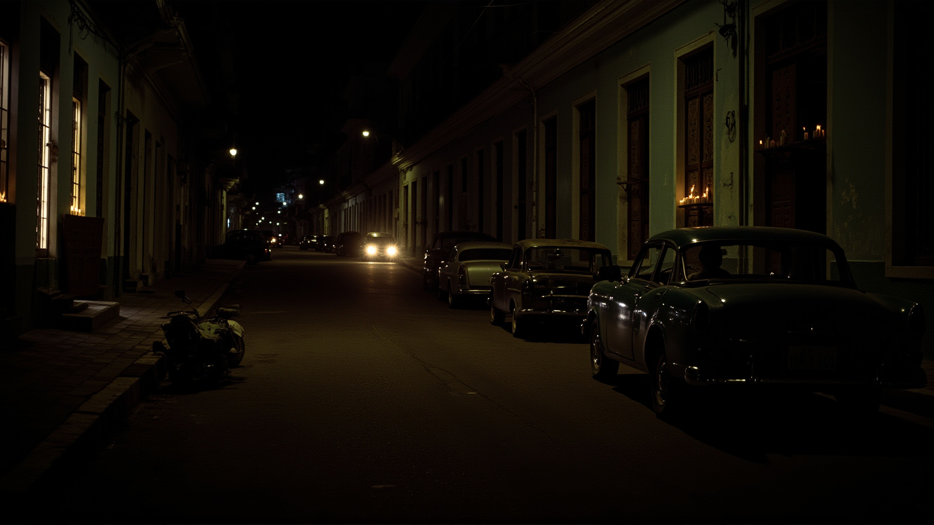 A Havana street at night lit only by candles in doorways, classic cars parked in shadows, a single generator humming in the distance, warm humid atmosphere