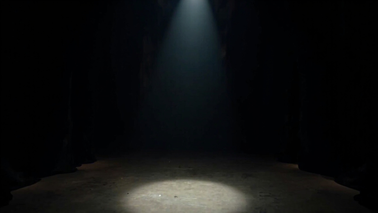 Theater stage with spotlight, dark background, suggesting intimate dramatic space