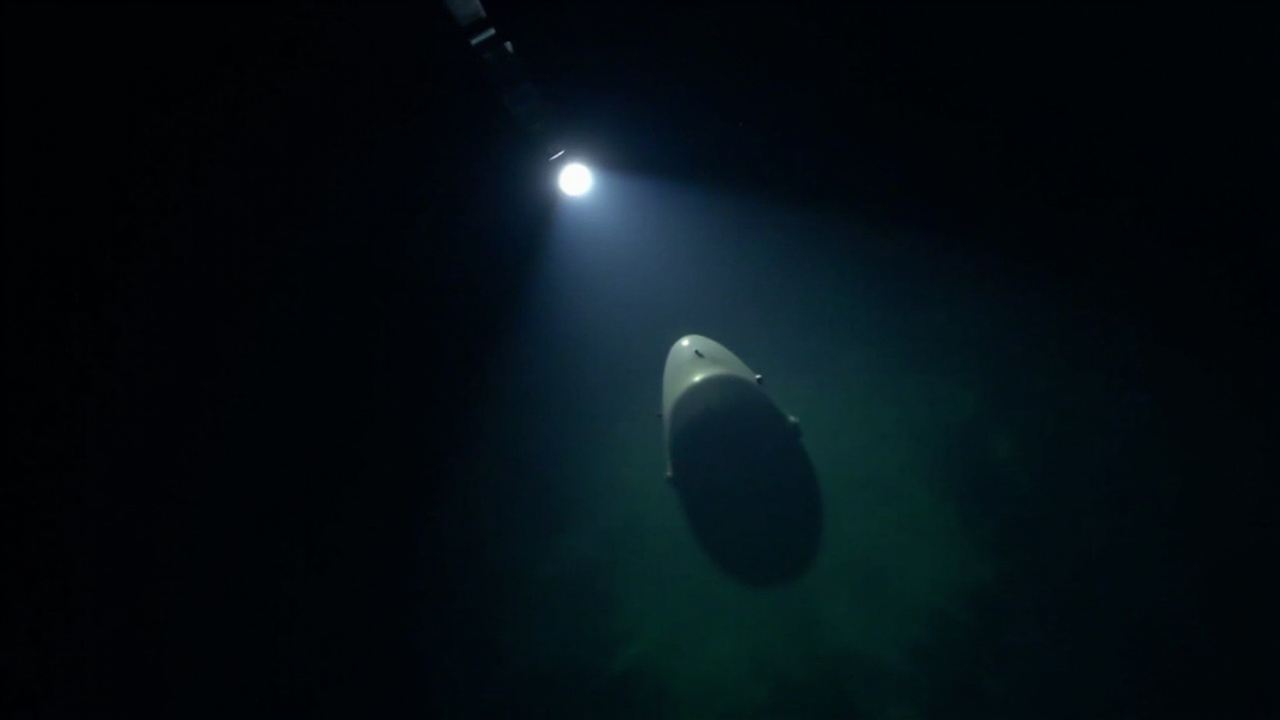 A naval mine visible in dark water, illuminated by a flashlight from a patrol boat