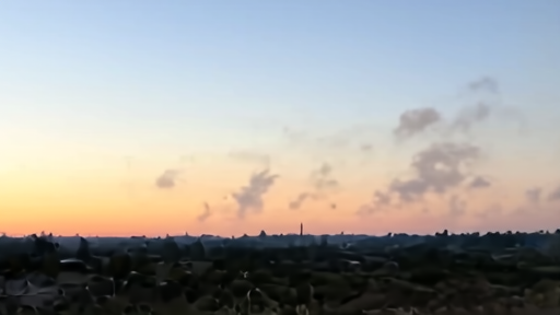 Smoke rising from a distant skyline at dusk, viewed from a military observation point