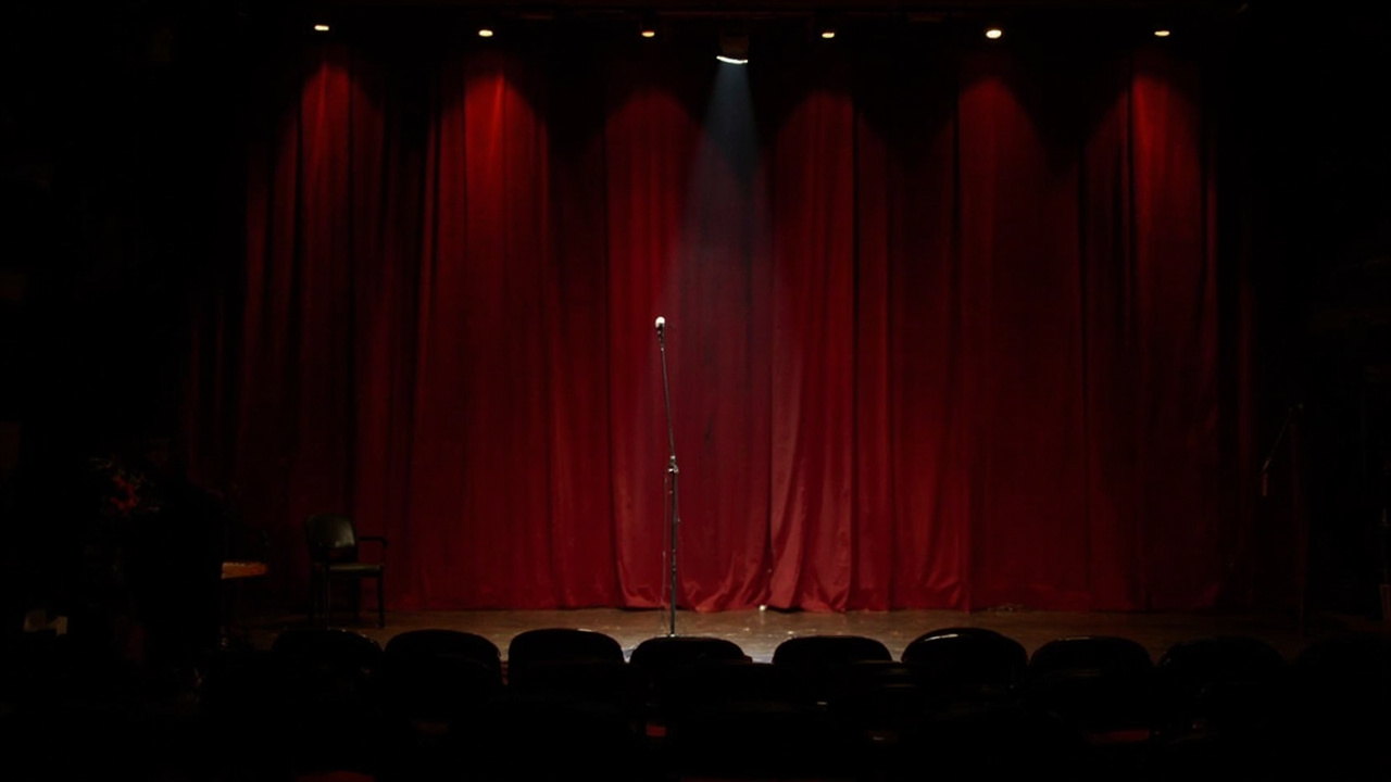 Las Vegas comedy club stage with dramatic spotlight, empty microphone stand center stage