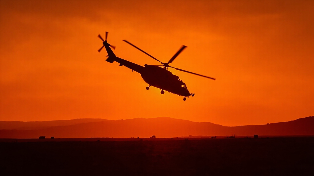 HH-60 Pave Hawk helicopter silhouetted against dusk sky during combat search and rescue operation over Iranian landscape