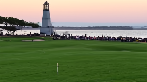 Matt Fitzpatrick walks off the eighteenth green at Harbour Town after the winning putt, tartan plaid jacket folded on the ground behind him, the Calibogue Sound lighthouse visible in the distance.