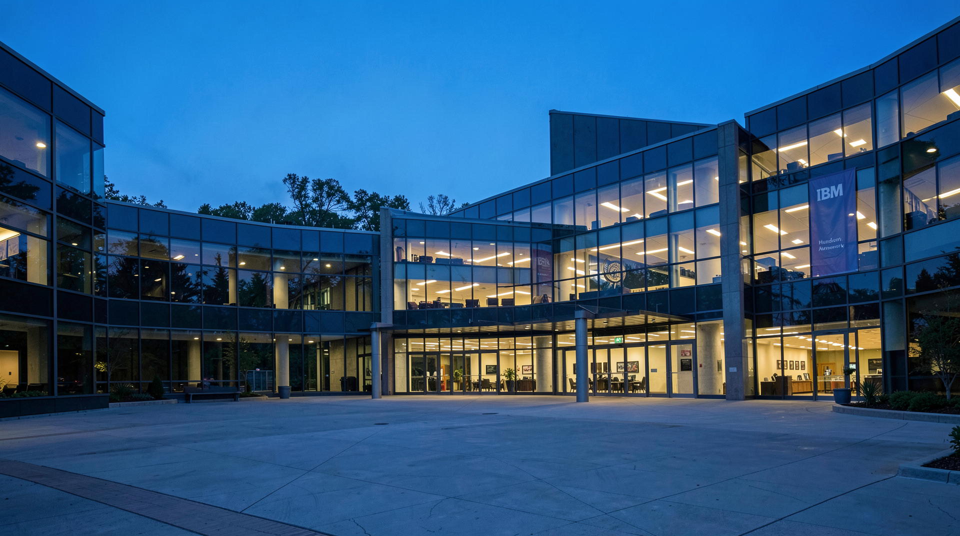 IBM's Armonk, New York headquarters at dusk with the lobby glass lit and a quiet investor-relations queue visible through the windows.
