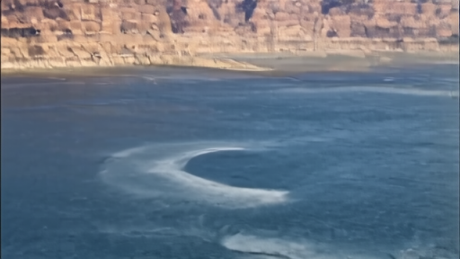 Glen Canyon Dam at Lake Powell on an Earth Day morning, the light-colored bathtub ring on sandstone walls visible above the lowered waterline, a Reclamation service truck on the access road