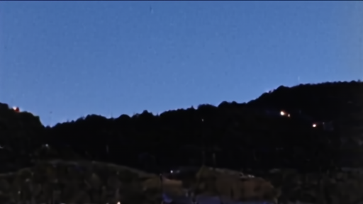 Dark hills on the Lebanese border at night, a distant flash of artillery visible