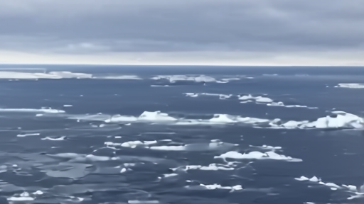 A NOAA research aircraft flying low over a dark Southern Ocean with ice floes visible, instrument boom extending from nose, cloud deck above