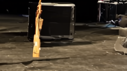 A mid-sized arena concert stage on a Thursday afternoon, risers dark, a single acoustic guitar case sitting at center stage left, a skateboard leaning against a speaker cabinet.