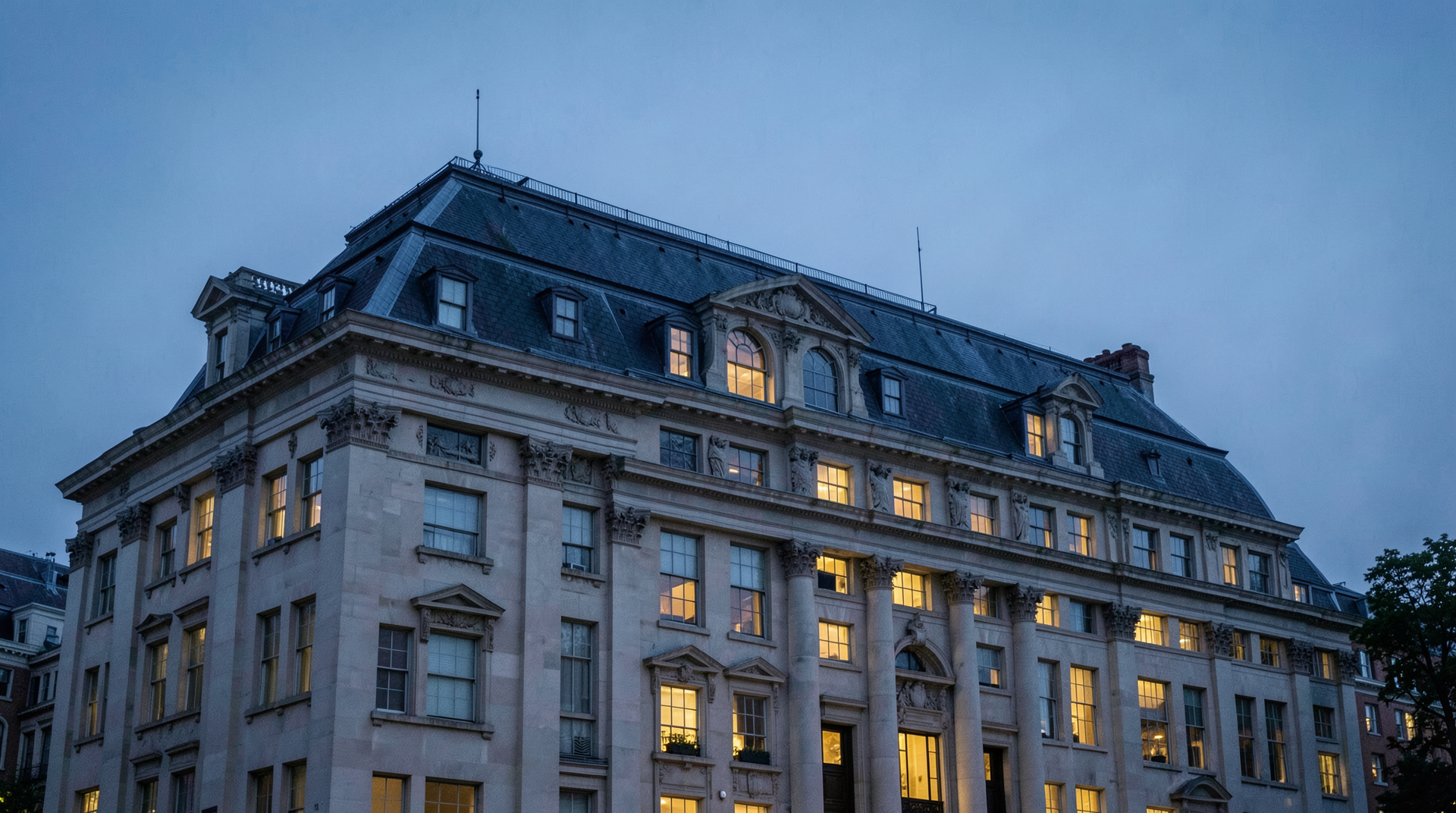 Eisenhower Executive Office Building exterior at evening with selectively lit OMB-side windows