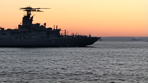 A US Navy guided-missile destroyer at dusk in the Arabian Sea with helicopter overhead.