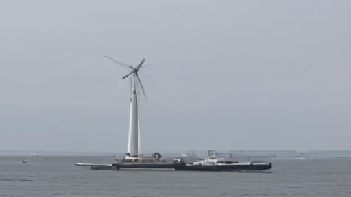 An offshore wind turbine being lowered onto a barge by a heavy-lift crane.