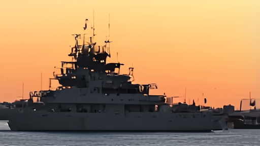 A Royal Navy minehunter and a French Marine Nationale frigate at anchor in a Gulf port