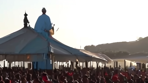 Pope Leo XIV at an open-air Mass in Cameroon, raising a chalice under midday sun