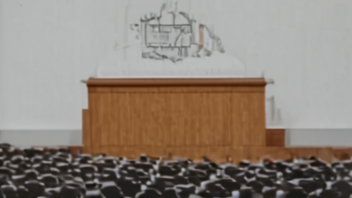 Empty Columbia University Pulitzer announcement room with the institutional crest behind a wooden lectern and rows of empty chairs
