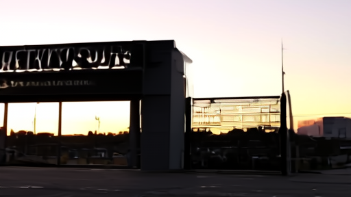The Lionsgate Studios entrance in Santa Monica at dusk, the corporate signage backlit, with an empty studio backlot beyond