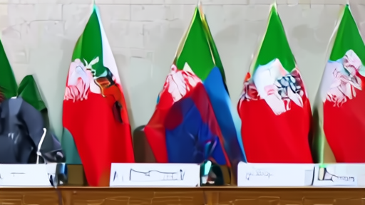 Wang Yi and Abbas Araghchi shaking hands across a table in Beijing with translators at flanking microphones.