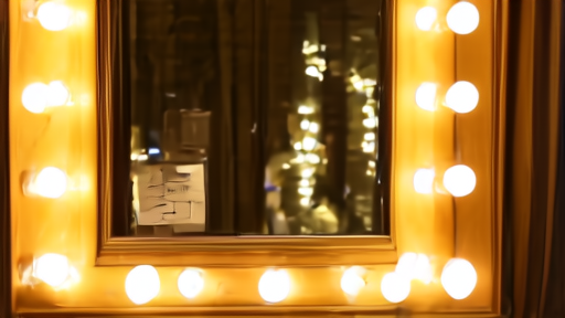 A backstage dressing room mirror ringed in lights with three printed nomination cards taped to the glass and a half-pinned dramaturg's note in the corner.