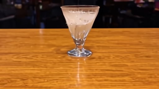 An empty margarita glass on a polished bar, salt rim still intact, the late-evening room mostly cleared.