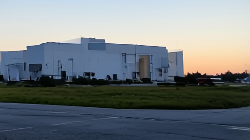 SpaceX Hawthorne campus at dawn with a Falcon 9 transport vehicle in the foreground