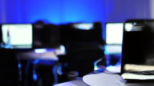 Empty open-plan office at Meta with rows of laptops on desks and a single screen glowing in shallow focus