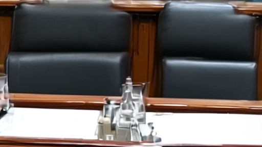 Senate Appropriations Defense subcommittee dais with witness chairs facing senators, water glasses, briefing papers, no faces visible.