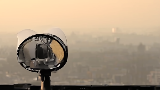 Atmospheric sampling equipment on a rooftop with hazy skyline and small filter cassette.
