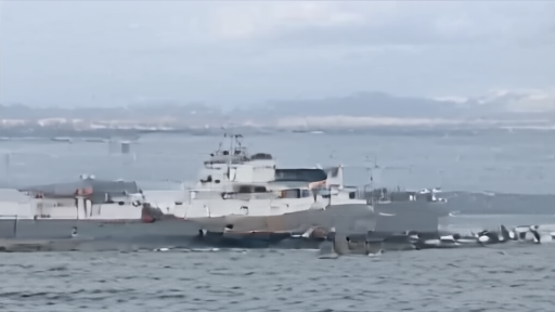 A damaged cargo ship near a Black Sea port under an overcast sky