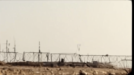 Subsea cable landing station in the Persian Gulf with a fenced perimeter under flat afternoon light.