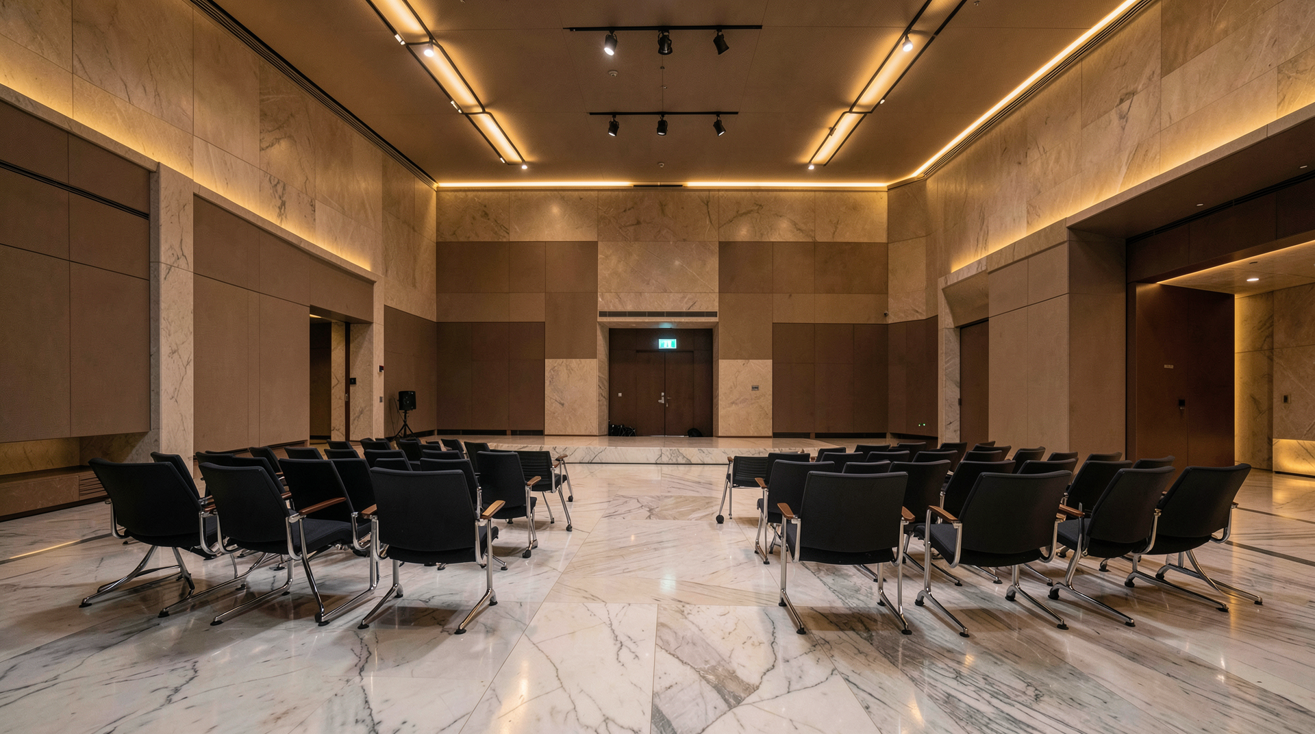 The empty Vatican Synod Hall with chairs arranged for a panel discussion, low warm lighting, no people present.