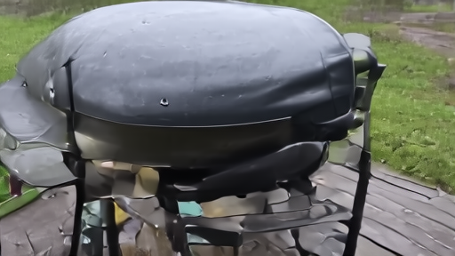A covered backyard grill on a rainy Mid-Atlantic Sunday morning with empty patio chairs, contrasted in framing with the implied dry warmth elsewhere.
