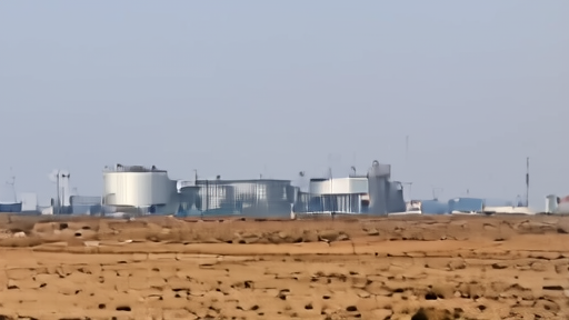 The SpaceX Colossus 1 data center exterior near Memphis, Tennessee, with cooling towers and electrical infrastructure under a hazy Memorial Day sky.