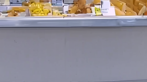 A deli counter case with headcheese visible behind a closed-for-recall paper sign, fluorescent lighting overhead.