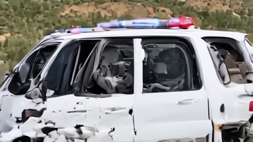 A damaged Lebanese ambulance with paramedic gear scattered outside, Arab Salim hillside in the background.