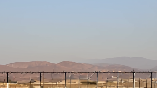 A uranium hexafluoride storage facility exterior at Natanz with light haze on the horizon and security fencing visible.