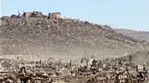 A hilltop fortress in southern Lebanon seen through a military checkpoint and dust