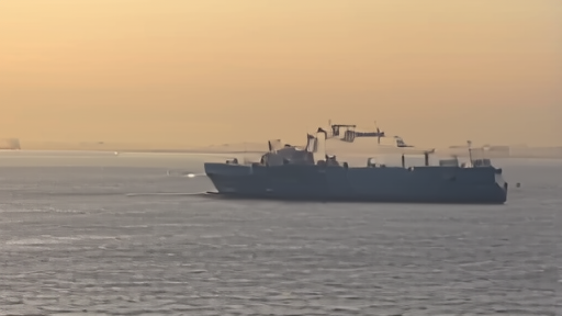 A cargo vessel moves through a narrow Red Sea shipping lane under hazy morning light