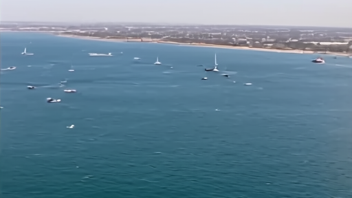 Aerial view of the Strait of Hormuz with military vessels and a near-empty shipping lane