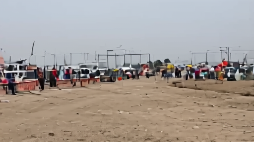 A closed crossing gate with aid trucks and families waiting nearby.