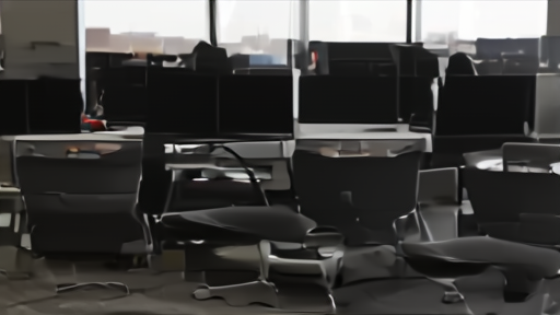 A quiet television newsroom with empty anchor chairs and control-room monitors
