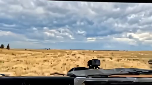 Dry grassland under distant lightning with a fire-weather map on a dashboard
